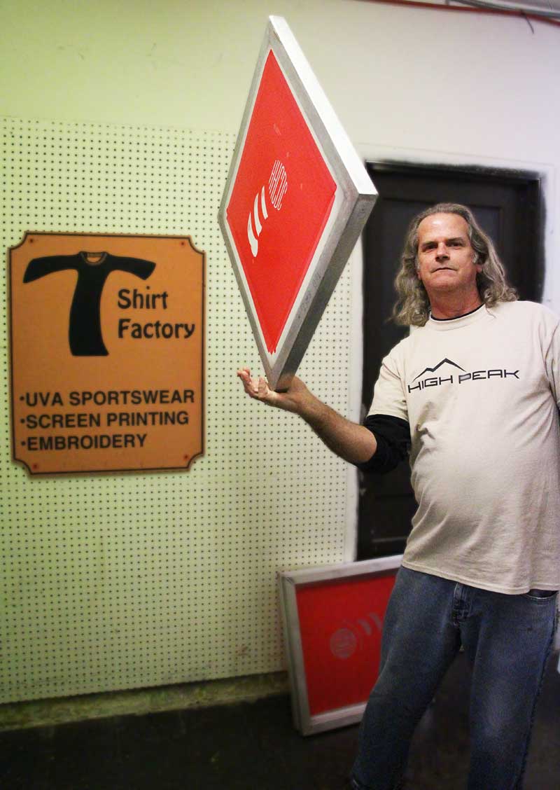 Guy holding screen for printing hats