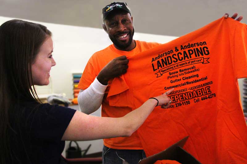 Satisfied customer holding up a quickly delivered shirt