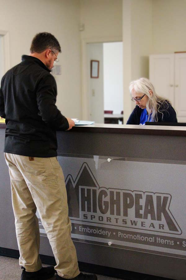 Customer picking up embroidered shirts