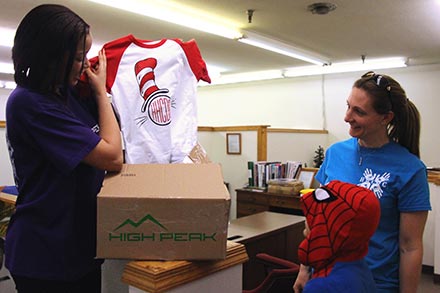 Employee holding up shirt for customer