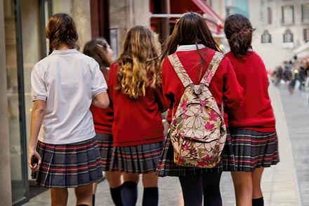 Three private school kids with backpacks